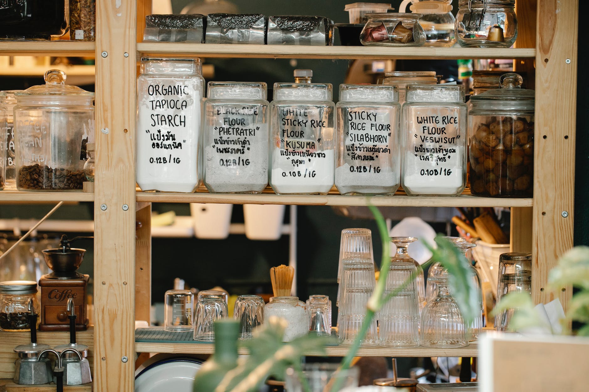 Photo of aesthetic minimalist zero waste pantry, featuring matching jars and a coffee setup.

